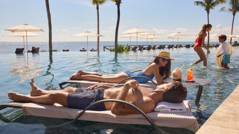 Famille au bord de la piscine du Hilton Cancun All Inclusive Resort