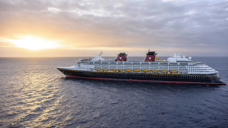 Disney Cruise Line ship sailing across the ocean at sunset