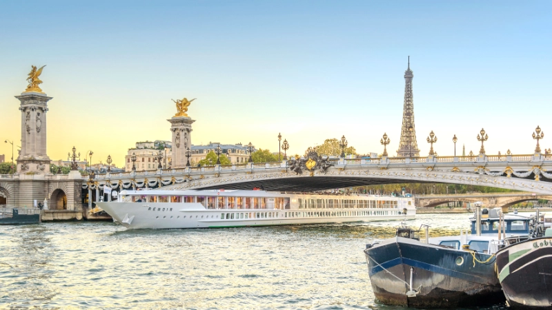 Renoir CroisiEurope river cruise ship sailing on the Seine beneath Pont Alexandre III with the Eiffel Tower in the background