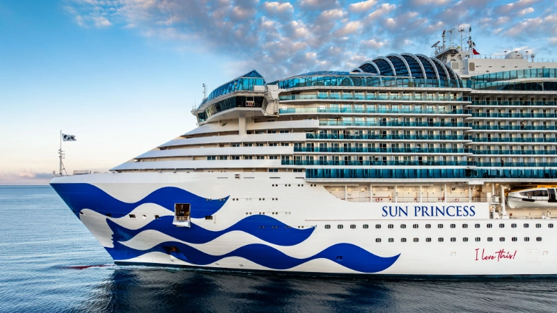 Sun Princess cruise ship sailing across the open ocean under a partly cloudy sky