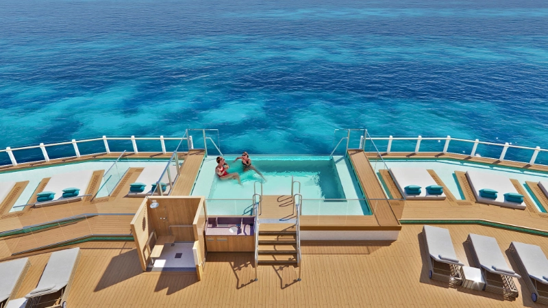 Infinity pool on the deck of a norwegian cruise ship overlooking clear turquoise ocean waters