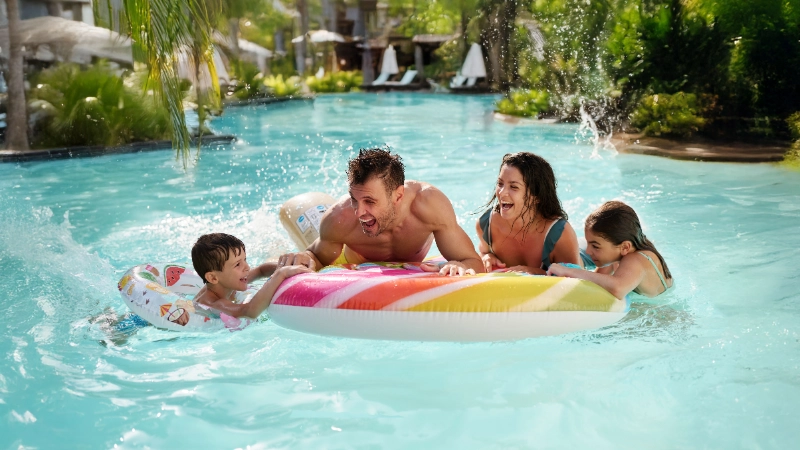 Famille heureuse jouant dans la piscine