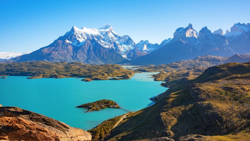 Vue panoramique sur un lac turquoise étincelant entouré de majestueuses montagnes enneigées