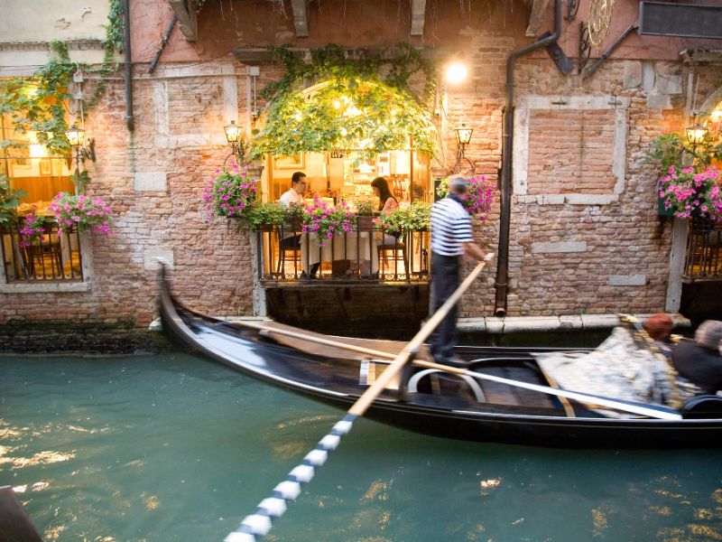 traditional black gondola gliding along Venice canal