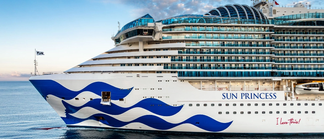 Sun Princess cruise ship sailing across the open ocean under a partly cloudy sky